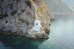 Το εκκλησάκι της Παναγίας που χτίστηκε από κρασί και χώμα στην άκρη του βράχου. Δείτε από ψηλά την δυσπρόσιτη «Κρασοπαναγιά» στα Μέθανα (βίντεο drone)